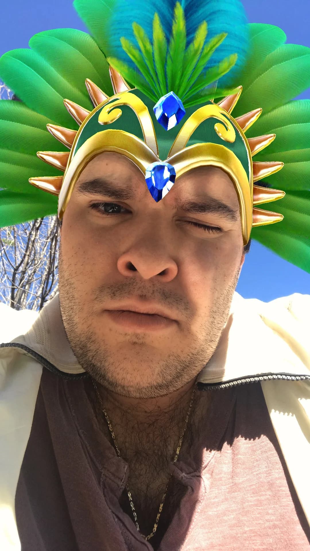 Jon in a colorful crown, outside beneath a blue sky