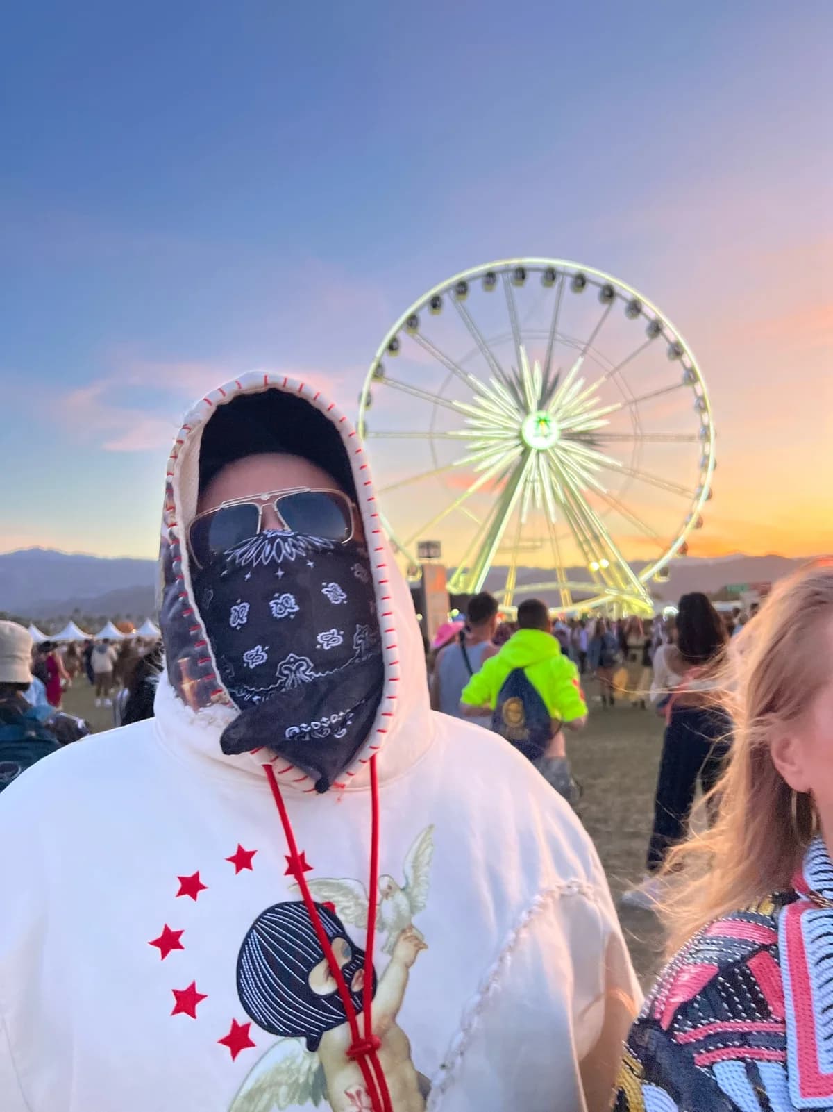 Jon wearing a bandana at a festival, with Laura at the edge of the original photograph